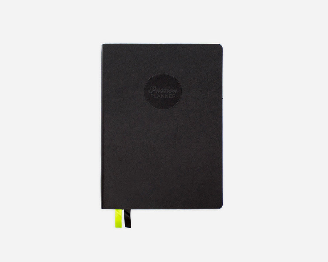 Black mid-year planner with a Passion Planner logo on a white background