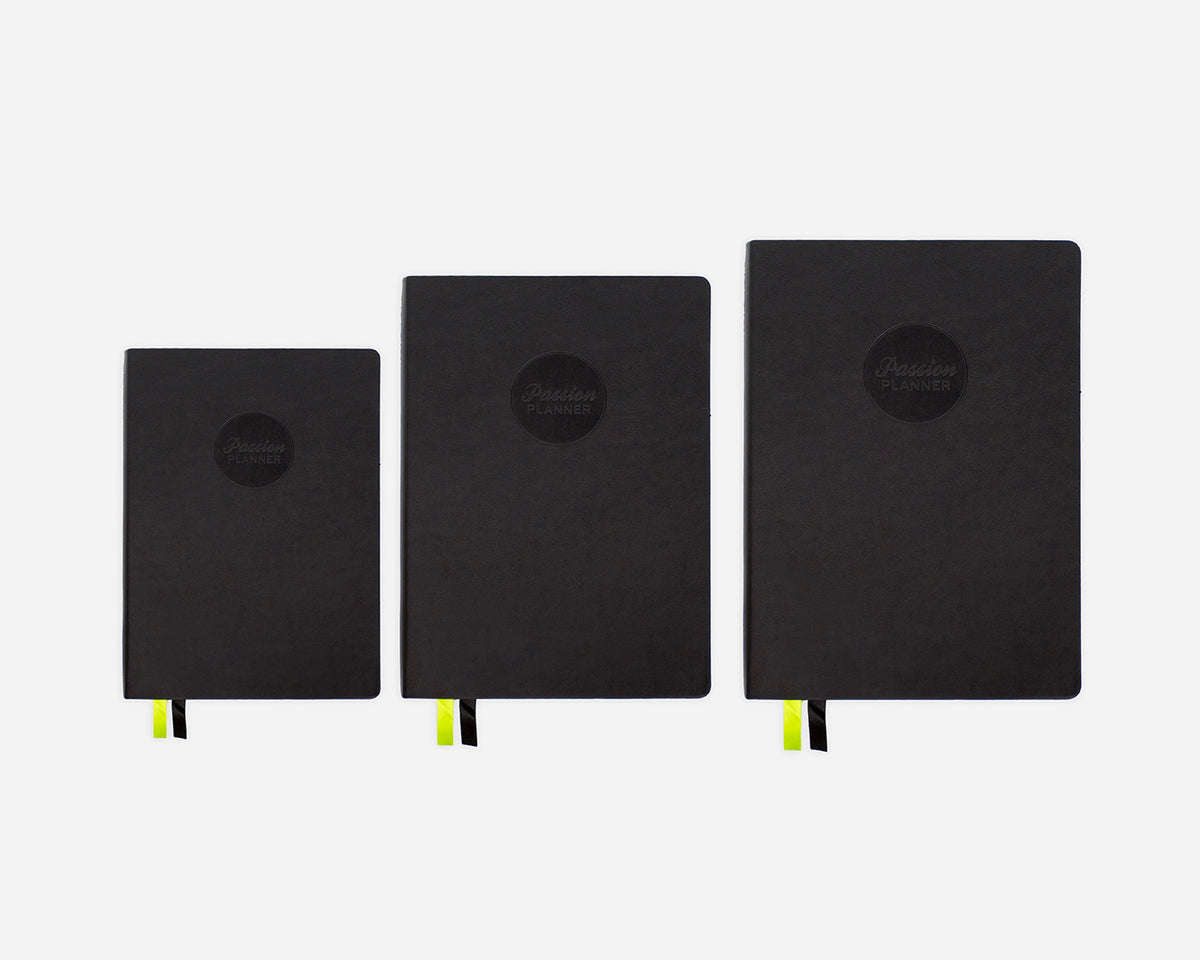 Three black mid-year planners of different sizes on a white background