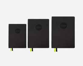 Three black mid-year planners of different sizes on a white background