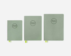 Three green hardcover planners of different sizes on a white background