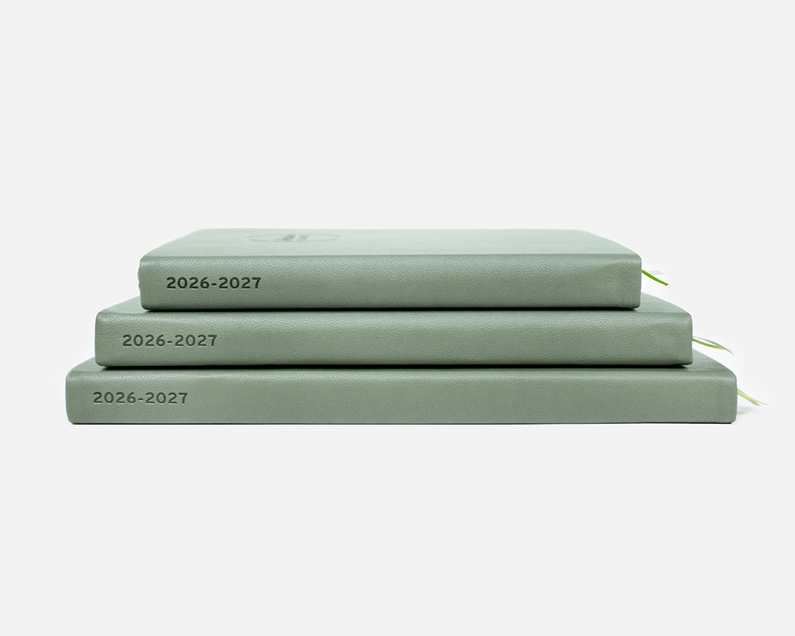 Three green planners stacked on a white background with '2026-2027' on the spines.