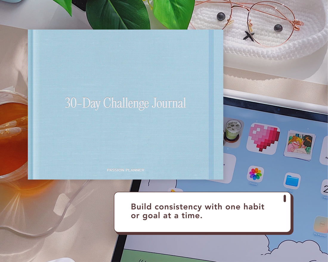 A light blue 30-Day Challenge Journal by Passion Planner is shown with a styled desk setting with a tablet, glasses, tea, and green leaves. A text bubble reads, &