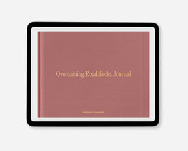 A digital journal titled 'Overcoming Roadblocks Journal' with a dusty rose cover and gold lettering, framed in a black tablet on a light gray background.