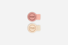 Two round, pink and cream colored pen loops with 'Passion Planner' text on a white background.