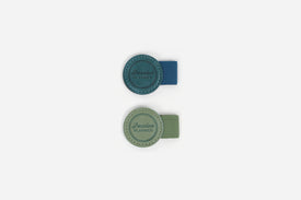 Two pen loops, one teal and one green, on a white backround