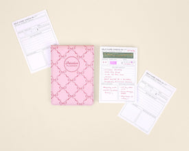 Pink notepad with self-care check-in sheets on a beige background