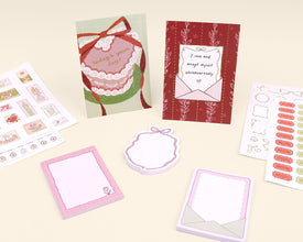 Collection of stationery items including cards, notepads, and stickers on a light background