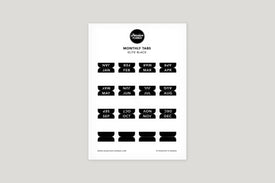 A sheet of black monthly tabs labeled with different months of the year, designed to be used in a planner.