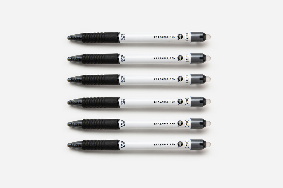 Six soft black pens lined up on a white background.